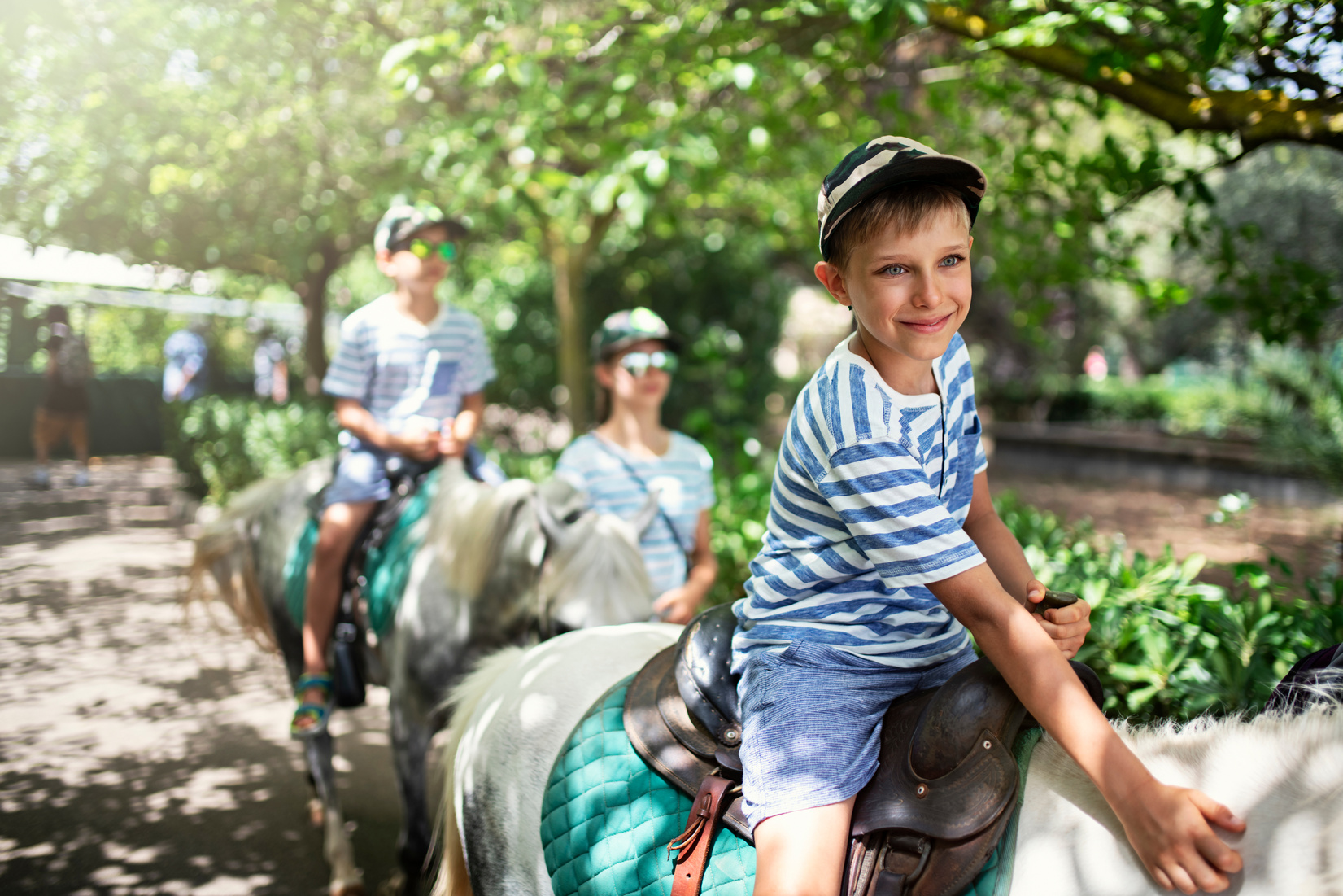 Kids enjoying riding ponies.